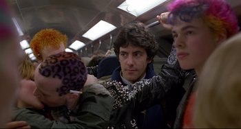 Movie still from “An American Werewolf in London” (1981), directed by John Landis – A group of young people riding on a train; Medium shot, Over the shoulder angle
