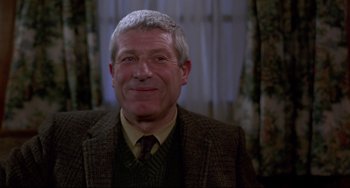 Movie still from “An American Werewolf in London” (1981), directed by John Landis – An older man wearing a suit and a tie; Close Up shot, Over the shoulder angle