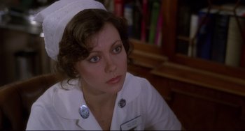 Movie still from “An American Werewolf in London” (1981), directed by John Landis – A woman wearing a nurse's uniform sitting in front of a book shelf; Close Up shot, Over the shoulder angle