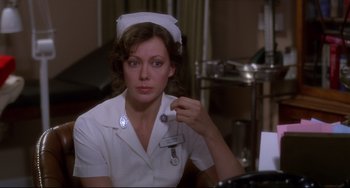 Movie still from “An American Werewolf in London” (1981), directed by John Landis – A woman in a nurse's uniform holding a stethoscope; Close Up shot, Over the shoulder angle