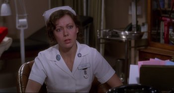 Movie still from “An American Werewolf in London” (1981), directed by John Landis – A woman in a nurse's uniform sitting at a desk; Close Up shot, Over the shoulder angle