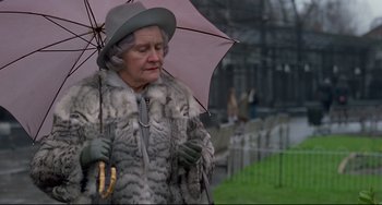 Movie still from “An American Werewolf in London” (1981), directed by John Landis – An older woman holding an umbrella while standing in the rain; Close Up shot, Low angle