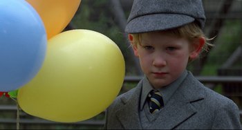 Movie still from “An American Werewolf in London” (1981), directed by John Landis – A boy in a suit and tie holding a yellow balloon; Close Up shot, Low angle