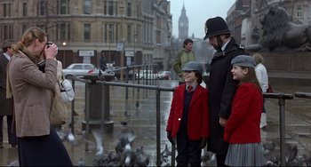 Movie still from “An American Werewolf in London” (1981), directed by John Landis – A man and two children standing in front of pigeons in the rain; Wide shot, Over the shoulder angle
