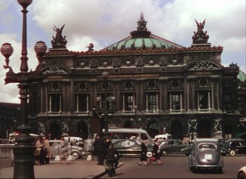 Movie still from “An American in Paris” (1951), directed by Vincente Minnelli – A group of cars parked on the side of a road; Extreme Wide shot, Low angle