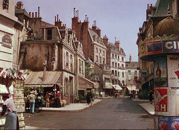 Movie still from “An American in Paris” (1951), directed by Vincente Minnelli – A street scene with a lot of buildings on both sides of the street; Extreme Wide shot, High angle
