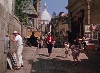 Movie still from “An American in Paris” (1951), directed by Vincente Minnelli – A group of people walking down a street; Wide shot, High angle