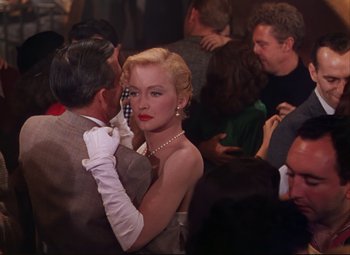 Movie still from “An American in Paris” (1951), directed by Vincente Minnelli – A man and a woman in formal wear at a party; Medium shot, Over the shoulder angle