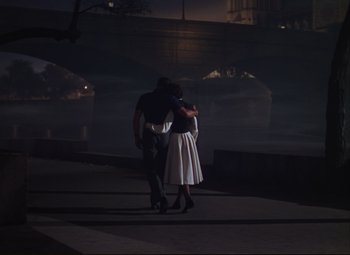 Movie still from “An American in Paris” (1951), directed by Vincente Minnelli – A man and a woman are walking in the dark; Wide shot, High angle