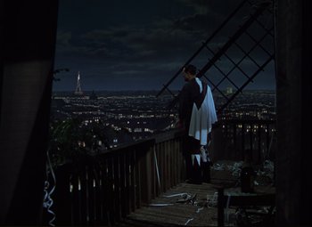 Movie still from “An American in Paris” (1951), directed by Vincente Minnelli – A man standing on top of a building looking at a city; Extreme Wide shot, High angle