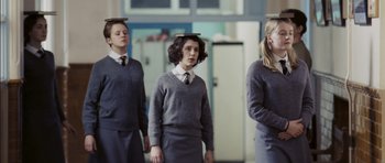 Movie still from “An Education” (2009), directed by Lone Scherfig – A group of young people standing next to each other in a room; Medium shot, Low angle