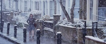 Movie still from “An Education” (2009), directed by Lone Scherfig – A person walking on a sidewalk in the snow; Wide shot, Over the shoulder angle