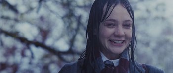 Movie still from “An Education” (2009), directed by Lone Scherfig – A young girl with wet hair smiles for the camera; Close Up shot, Over the shoulder angle