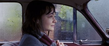 Movie still from “An Education” (2009), directed by Lone Scherfig – A woman sitting in the back of a car looking out the window; Close Up shot, Over the shoulder angle