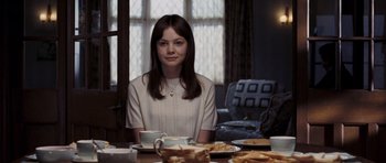 Movie still from “An Education” (2009), directed by Lone Scherfig – A woman sitting at a table with a plate of food; Medium shot, Over the shoulder angle