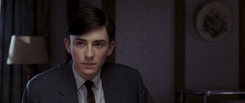 Movie still from “An Education” (2009), directed by Lone Scherfig – A man in a suit and tie looking at the camera; Close Up shot, Over the shoulder angle