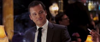 Movie still from “An Education” (2009), directed by Lone Scherfig – A man in a suit and tie looking to his left; Close Up shot, Over the shoulder angle