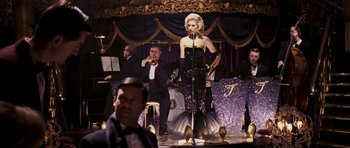 Movie still from “An Education” (2009), directed by Lone Scherfig – A wax figure of marilyn monroe is on display in front of a group of people; Wide shot, Over the shoulder angle