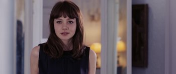 Movie still from “An Education” (2009), directed by Lone Scherfig – A young woman with long brown hair wearing a black dress; Close Up shot, Over the shoulder angle