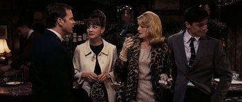 Movie still from “An Education” (2009), directed by Lone Scherfig – A group of people standing next to each other in a room; Medium shot, Over the shoulder angle