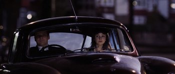 Movie still from “An Education” (2009), directed by Lone Scherfig – A woman sitting in the driver's seat of an old car; Medium shot, High angle