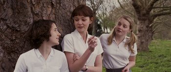 Movie still from “An Education” (2009), directed by Lone Scherfig – A group of young women standing next to a tree; Medium shot, Low angle