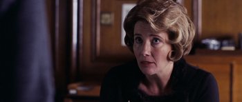 Movie still from “An Education” (2009), directed by Lone Scherfig – An older woman sitting in front of a wooden wall; Close Up shot, Over the shoulder angle