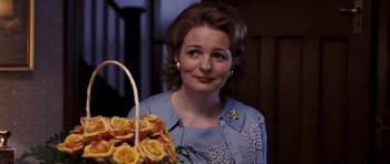 Movie still from “An Education” (2009), directed by Lone Scherfig – A woman in a blue dress holding a basket of flowers; Close Up shot, Over the shoulder angle