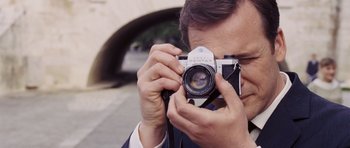 Movie still from “An Education” (2009), directed by Lone Scherfig – A man taking a picture with a camera; Close Up shot, High angle