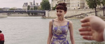 Movie still from “An Education” (2009), directed by Lone Scherfig – A woman in a purple dress standing next to a body of water; Medium shot, Over the shoulder angle
