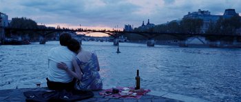 Movie still from “An Education” (2009), directed by Lone Scherfig – A woman sitting on a pier next to a body of water; Wide shot, Over the shoulder angle