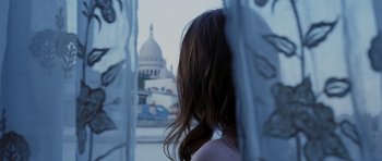 Movie still from “An Education” (2009), directed by Lone Scherfig – A woman looking out a window at a building; Close Up shot, Over the shoulder angle
