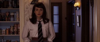 Movie still from “An Education” (2009), directed by Lone Scherfig – A woman in a dress shirt and tie standing in front of a door; Medium shot, Over the shoulder angle
