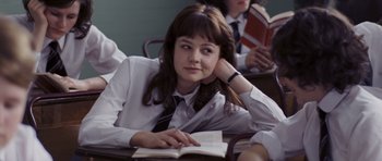 Movie still from “An Education” (2009), directed by Lone Scherfig – A young woman is reading a book in a classroom; Close Up shot, Over the shoulder angle