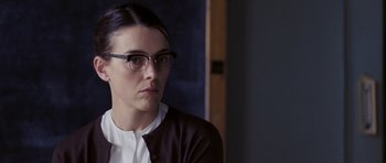 Movie still from “An Education” (2009), directed by Lone Scherfig – A woman wearing glasses sitting in front of a wall; Close Up shot, Over the shoulder angle