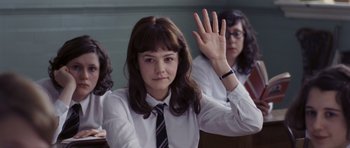 Movie still from “An Education” (2009), directed by Lone Scherfig – A woman in a white shirt and a black and white striped tie waves; Medium shot, Low angle