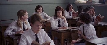 Movie still from “An Education” (2009), directed by Lone Scherfig – A group of young people sitting at desks reading books; Medium shot, High angle