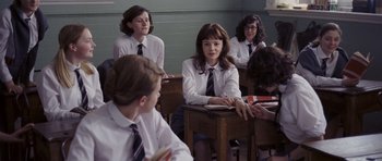 Movie still from “An Education” (2009), directed by Lone Scherfig – A group of young people sitting at a table; Medium shot, Over the shoulder angle