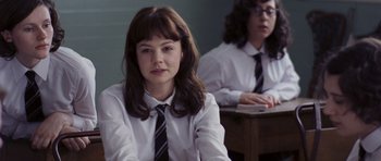 Movie still from “An Education” (2009), directed by Lone Scherfig – A woman in a white shirt and a black tie; Close Up shot, Over the shoulder angle