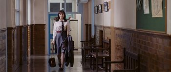 Movie still from “An Education” (2009), directed by Lone Scherfig – A woman walking down a hallway holding a bag; Wide shot, Low angle