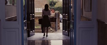 Movie still from “An Education” (2009), directed by Lone Scherfig – A woman is walking through a door way; Wide shot, Over the shoulder angle