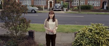 Movie still from “An Education” (2009), directed by Lone Scherfig – A woman standing on a sidewalk in front of a house; Wide shot, High angle