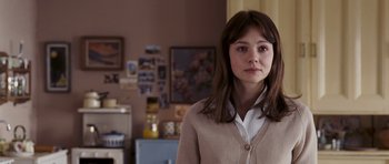 Movie still from “An Education” (2009), directed by Lone Scherfig – A woman standing in front of a wall in a room; Close Up shot, Over the shoulder angle