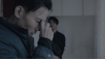 Movie still from “An Elephant Sitting Still” (2018), directed by Bo Hu – A man standing next to another man in a room; Close Up shot, Over the shoulder angle