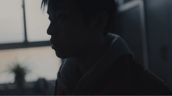 Movie still from “An Elephant Sitting Still” (2018), directed by Bo Hu – A young man looking out a window at night; Extreme Close Up shot, Low angle