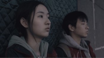 Movie still from “An Elephant Sitting Still” (2018), directed by Bo Hu – Two young people sitting next to each other on a bus; Close Up shot, Low angle
