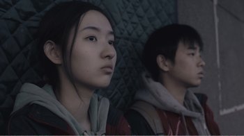 Movie still from “An Elephant Sitting Still” (2018), directed by Bo Hu – Two young people sitting side by side on a bus; Close Up shot, Low angle