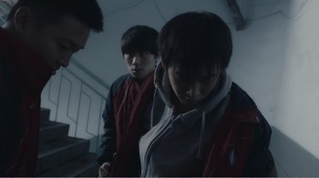Movie still from “An Elephant Sitting Still” (2018), directed by Bo Hu – A group of young men standing next to each other on stairs; Medium shot, High angle