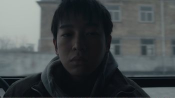 Movie still from “An Elephant Sitting Still” (2018), directed by Bo Hu – A young man in a car wearing a scarf; Close Up shot, Low angle