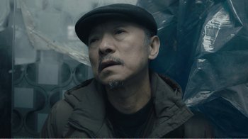 Movie still from “An Elephant Sitting Still” (2018), directed by Bo Hu – A person wearing a hat; Close Up shot, Low angle